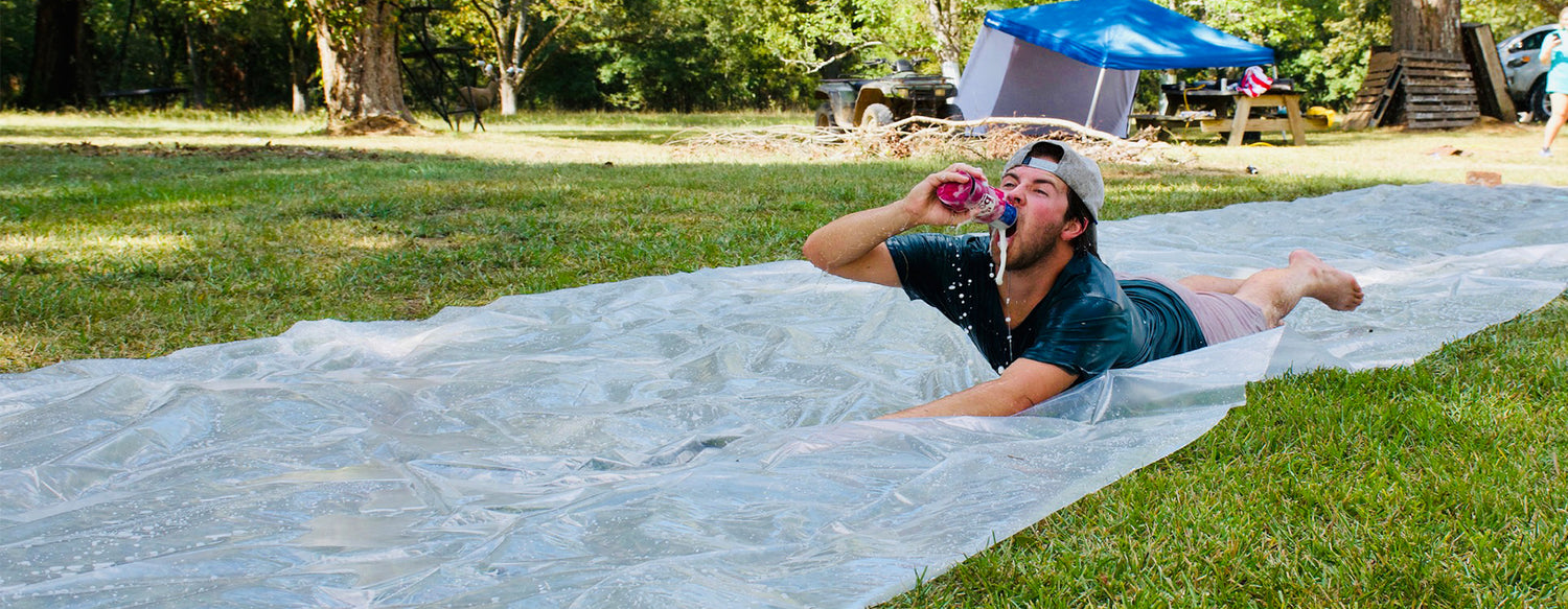 guy on slip and slide drinking a beer